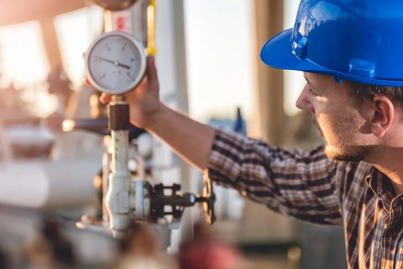 Commercial plumber inspecting a pressure gauge